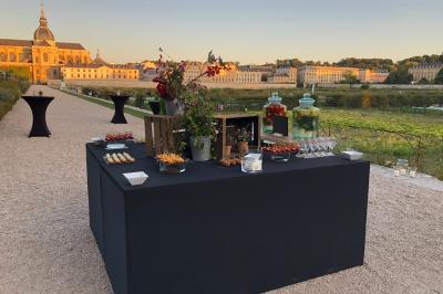 Miniature Traiteur Magny-les-Hameaux (Yvelines) - Lars Traiteur #24 Gâteau de fête décoré de bougies scintillantes, entouré de desserts et de convives en arrière-plan flou.