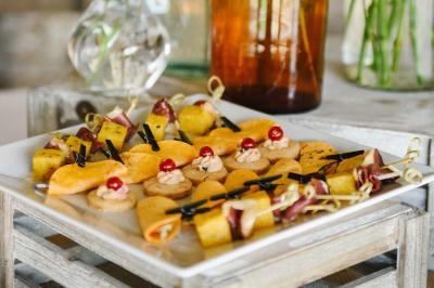 Miniature Traiteur Magny-les-Hameaux (Yvelines) - Lars Traiteur #30 Gâteau de fête décoré de bougies scintillantes, entouré de desserts et de convives en arrière-plan flou.