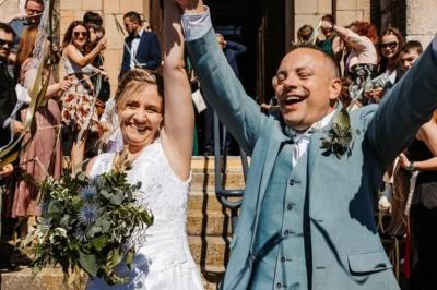 Miniature Justine Compagnon Wedding #9 Façade d'une maison ancienne avec volets bleus, entourée de végétation et éclairée par des guirlandes lumineuses.