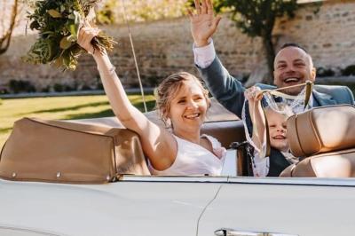 Miniature Justine Compagnon Wedding #11 Façade d'une maison ancienne avec volets bleus, entourée de végétation et éclairée par des guirlandes lumineuses.