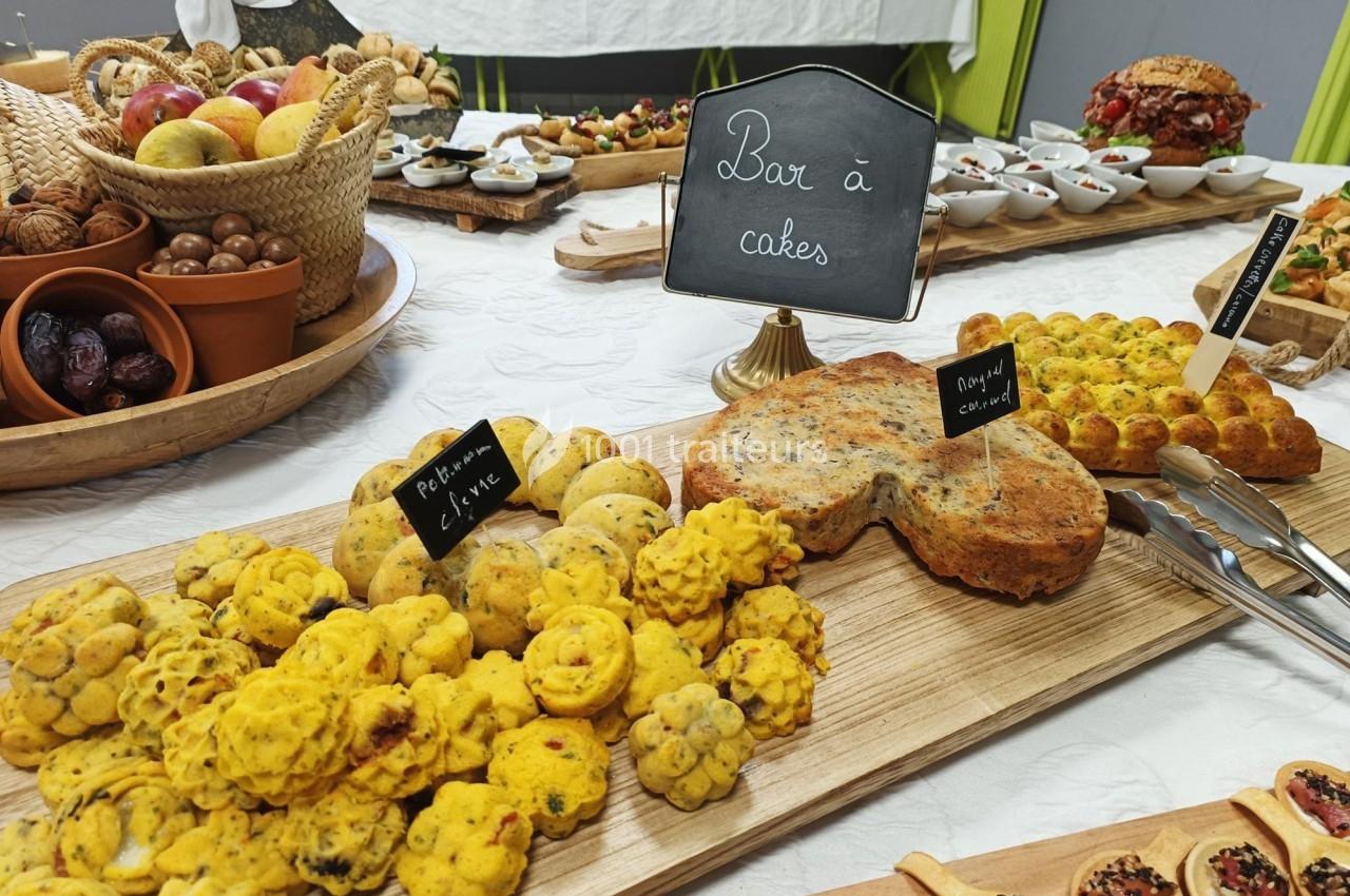 Buffet avec divers cakes salés, fruits et amuse-bouches présentés sur une table décorée.
