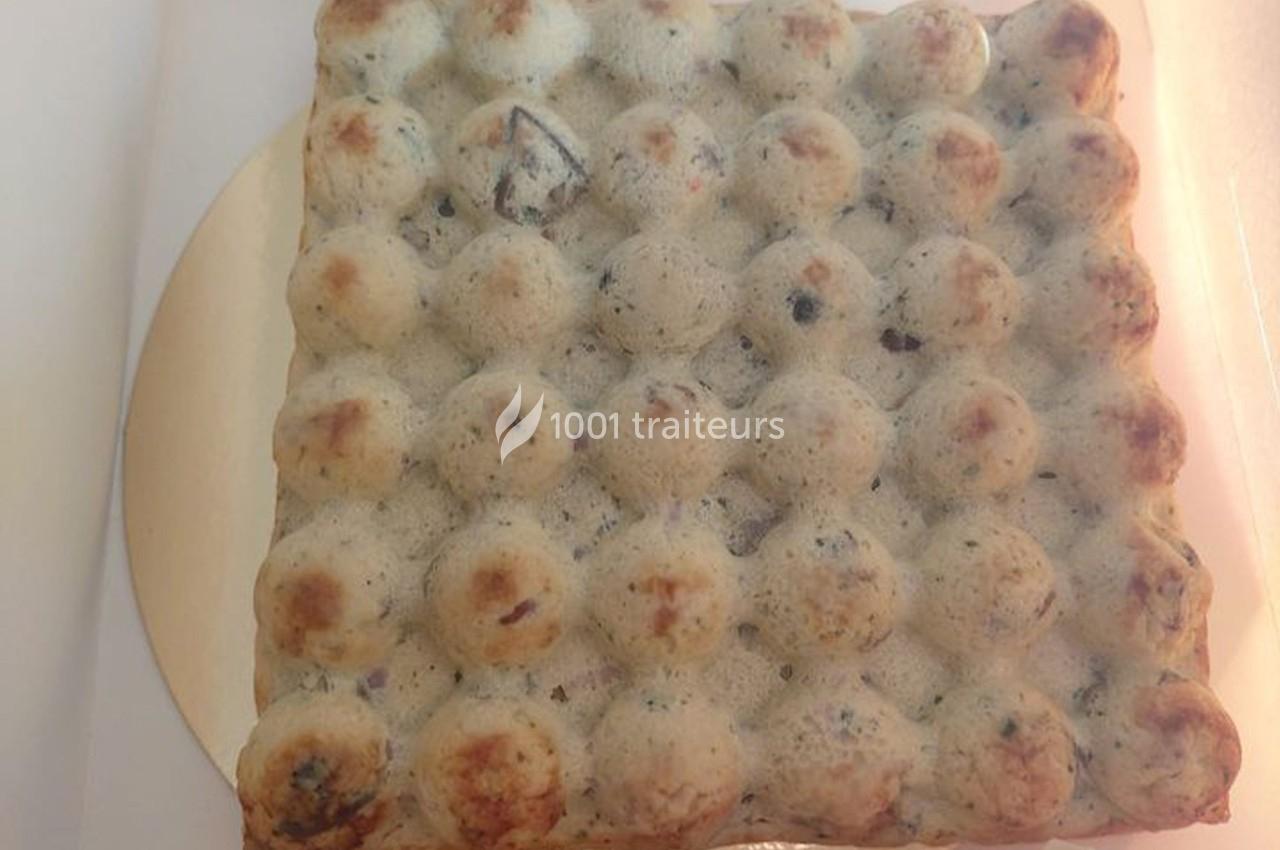 Gaufre carrée à bulles, légèrement dorée, avec des inclusions sombres visibles dans la pâte.