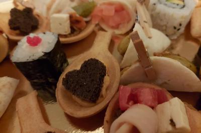 Assortiment de bouchées apéritives variées, incluant sushis, toasts et mini-brochettes, présenté sur un plateau.