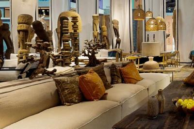 Tables en bois dressées avec des assiettes, des verres et des serviettes blanches dans une salle élégante.