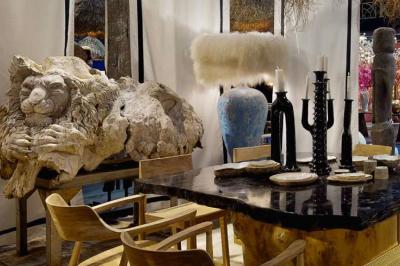 Tables en bois dressées avec des assiettes, des verres et des serviettes blanches dans une salle élégante.