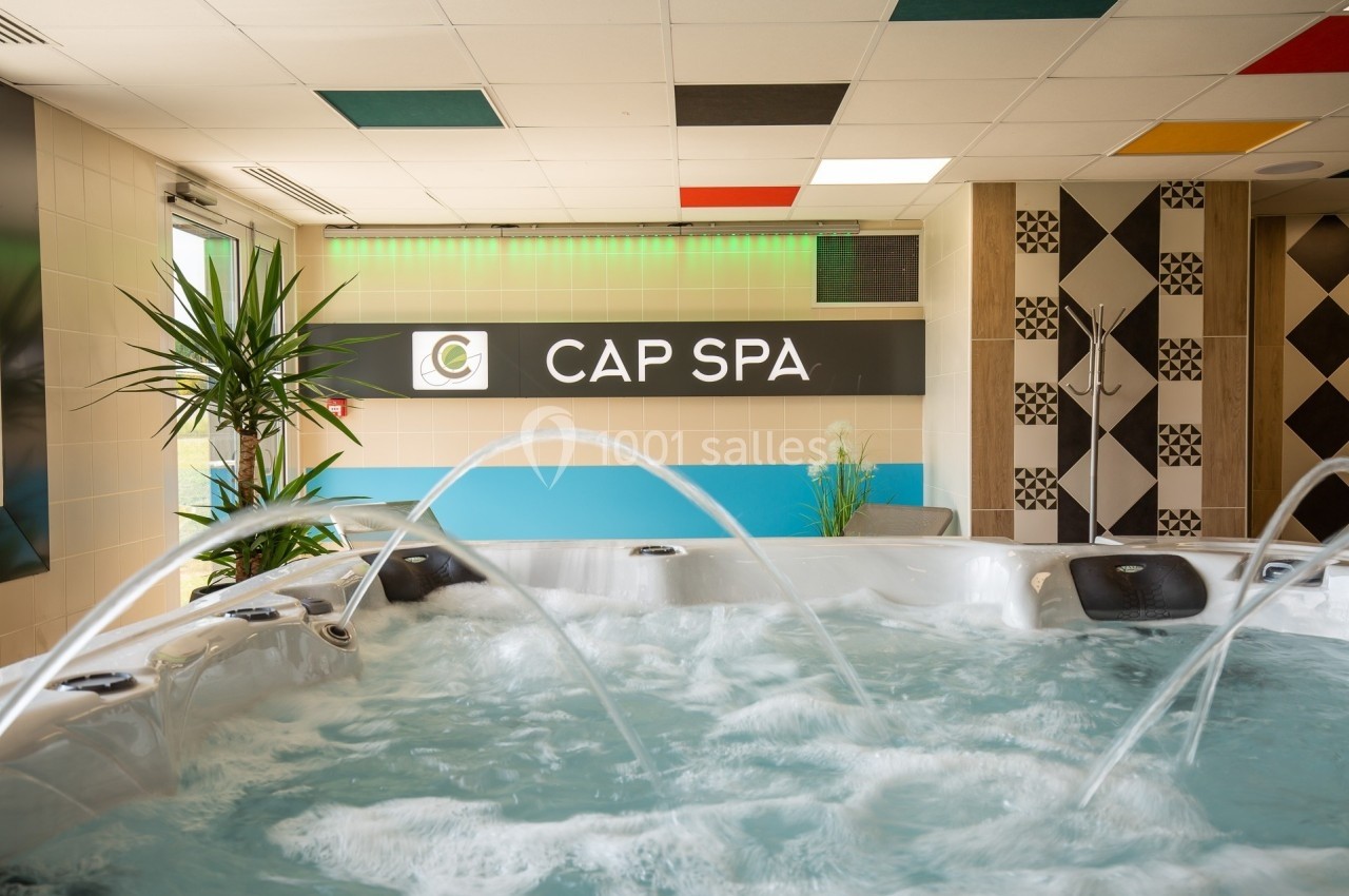 Bain à remous en fonctionnement dans un espace intérieur moderne avec plantes et décoration colorée.