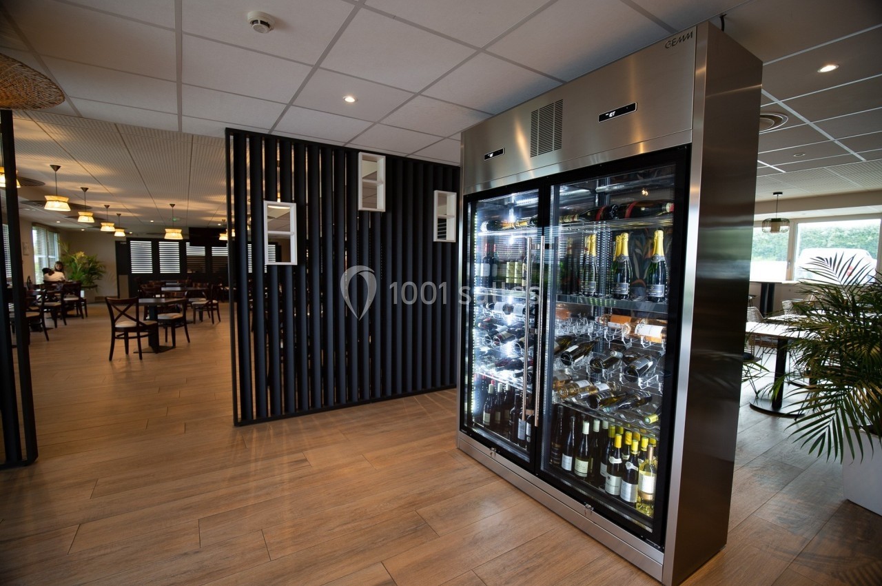 Vitrine réfrigérée contenant des bouteilles de vin et de champagne dans un espace de restauration moderne.