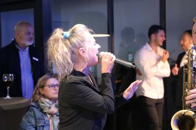 Deux artistes chantent et jouent de la musique en direct dans une ambiance lumineuse et chaleureuse.
