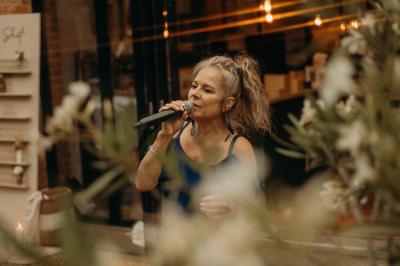Deux artistes chantent et jouent de la musique en direct dans une ambiance lumineuse et chaleureuse.