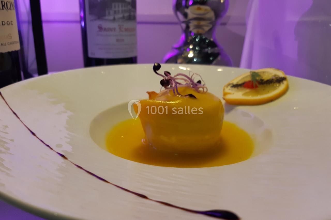 Location salle Comines (Nord) - Les Salons du Château - France Evénement #26 Plat gastronomique avec un dessert jaune brillant, nappé de sauce, décoré de pousses et accompagné d'une tranche d'orange.
