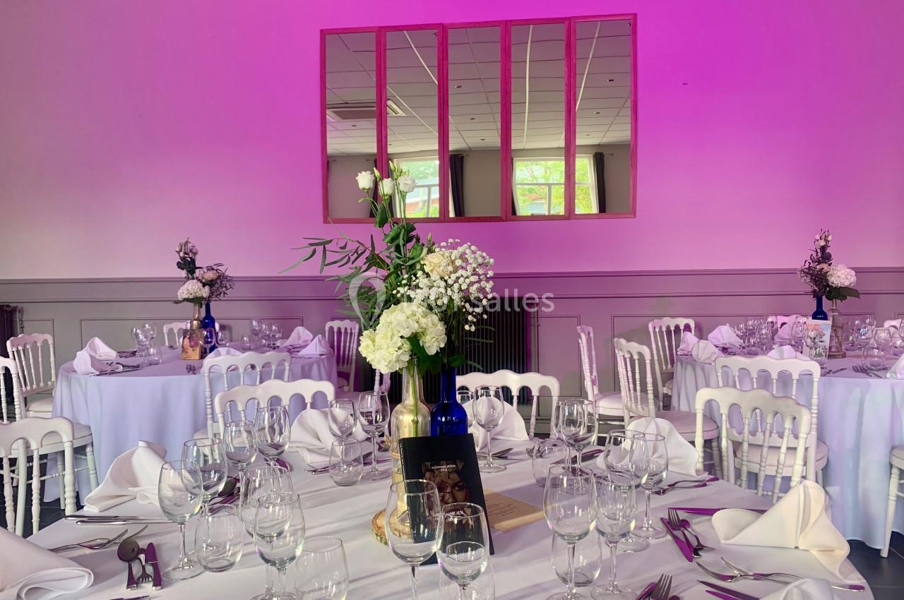 Location salle Comines (Nord) - Les Salons du Château - France Evénement #10 Salle de réception décorée avec des tables rondes, nappes blanches, verres, couverts et bouquets de fleurs.