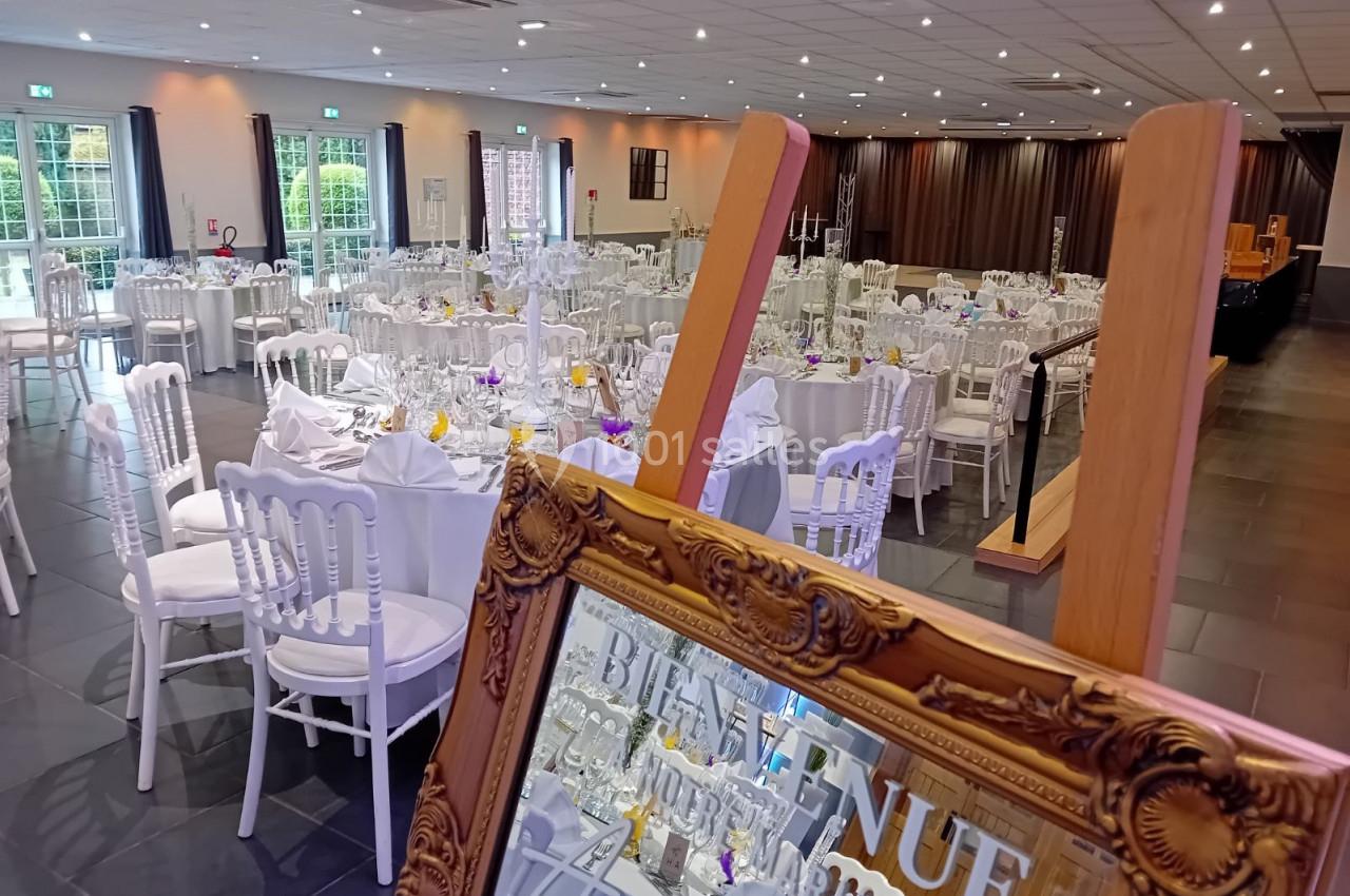 Location salle Comines (Nord) - Les Salons du Château - France Evénement #5 Salle de réception élégamment décorée avec des tables rondes dressées et un miroir doré au premier plan.