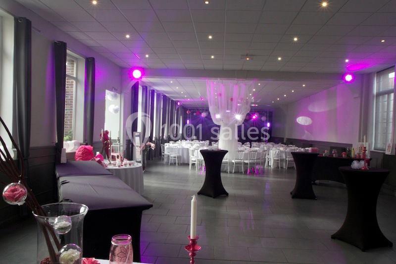 Location salle Comines (Nord) - Les Salons du Château - France Evénement #13 Salle de réception décorée avec des tables rondes, nappes blanches et éclairage rose tamisé.