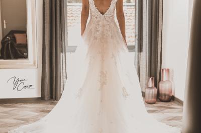 Miniature Loes Domaine du Truscin Femme assise, vêtue d'une robe blanche fluide, posant avec une expression sereine sur fond neutre.