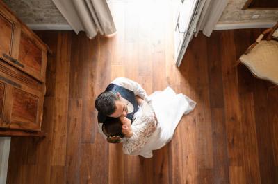 Miniature Mariage Alès Femme assise, vêtue d'une robe blanche fluide, posant avec une expression sereine sur fond neutre.