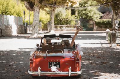 Miniature Mariage Corinne & Romain - Saint Alban  Femme assise, vêtue d'une robe blanche fluide, posant avec une expression sereine sur fond neutre.