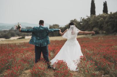 Miniature Mariage Sandrine & Yohan à Barjac Femme assise, vêtue d'une robe blanche fluide, posant avec une expression sereine sur fond neutre.