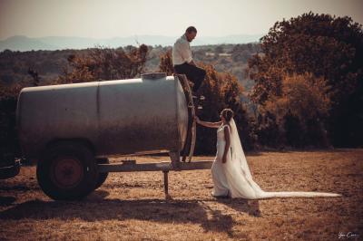 Miniature Séance photo couple - Le Coiron  Femme assise, vêtue d'une robe blanche fluide, posant avec une expression sereine sur fond neutre.