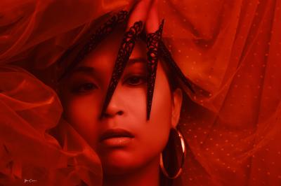 Miniature Shooting Mode Femme assise, vêtue d'une robe blanche fluide, posant avec une expression sereine sur fond neutre.