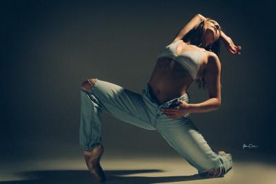 Miniature Shooting Portrait Danse  Femme assise, vêtue d'une robe blanche fluide, posant avec une expression sereine sur fond neutre.