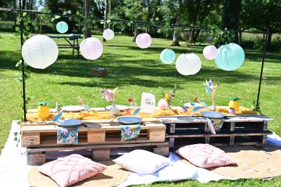 Table décorée avec des bougies torsadées, fleurs séchées et chemin de table rouge dans un cadre chaleureux.