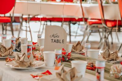 Table décorée avec des bougies torsadées, fleurs séchées et chemin de table rouge dans un cadre chaleureux.