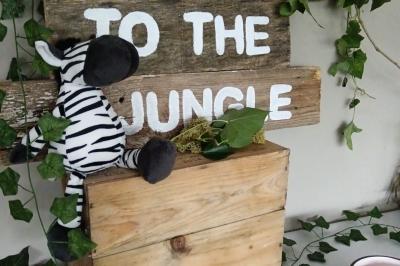 Table décorée avec des bougies torsadées, fleurs séchées et chemin de table rouge dans un cadre chaleureux.