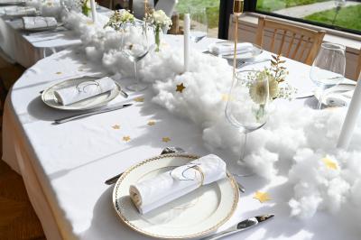 Table décorée avec des bougies torsadées, fleurs séchées et chemin de table rouge dans un cadre chaleureux.