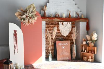 Table décorée avec des bougies torsadées, fleurs séchées et chemin de table rouge dans un cadre chaleureux.