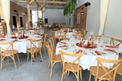 Table décorée avec des bougies torsadées, fleurs séchées et chemin de table rouge dans un cadre chaleureux.