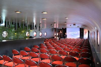 Une boule à facettes illumine une salle sombre avec des reflets lumineux, créant une ambiance festive.