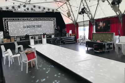 Une boule à facettes illumine une salle sombre avec des reflets lumineux, créant une ambiance festive.