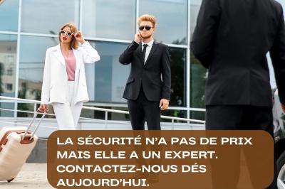 Un berger allemand assis, équipé d'un harnais, aux côtés d'une personne en tenue noire sur fond sombre.