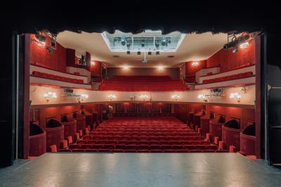 Façade du Théâtre Saint-Georges dans une rue calme avec des passants et des bâtiments environnants.