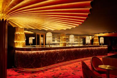 Miniature Auditorium Lido Intérieur d'une pièce aux motifs colorés et symétriques avec des murs en bois, des miroirs et un plafond lumineux.