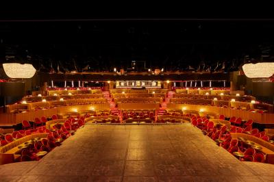 Miniature Auditorium Lido Intérieur d'une pièce aux motifs colorés et symétriques avec des murs en bois, des miroirs et un plafond lumineux.