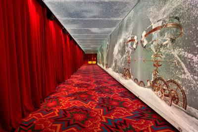 Miniature Couloir d'accueil Intérieur d'une pièce aux motifs colorés et symétriques avec des murs en bois, des miroirs et un plafond lumineux.