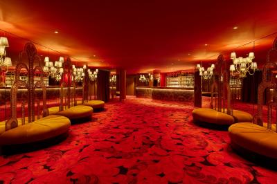 Miniature Salon des Fontaines Intérieur d'une pièce aux motifs colorés et symétriques avec des murs en bois, des miroirs et un plafond lumineux.