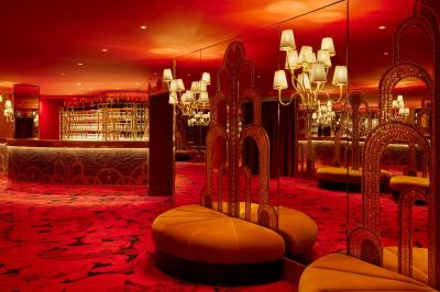 Miniature Salon des Fontaines Intérieur d'une pièce aux motifs colorés et symétriques avec des murs en bois, des miroirs et un plafond lumineux.