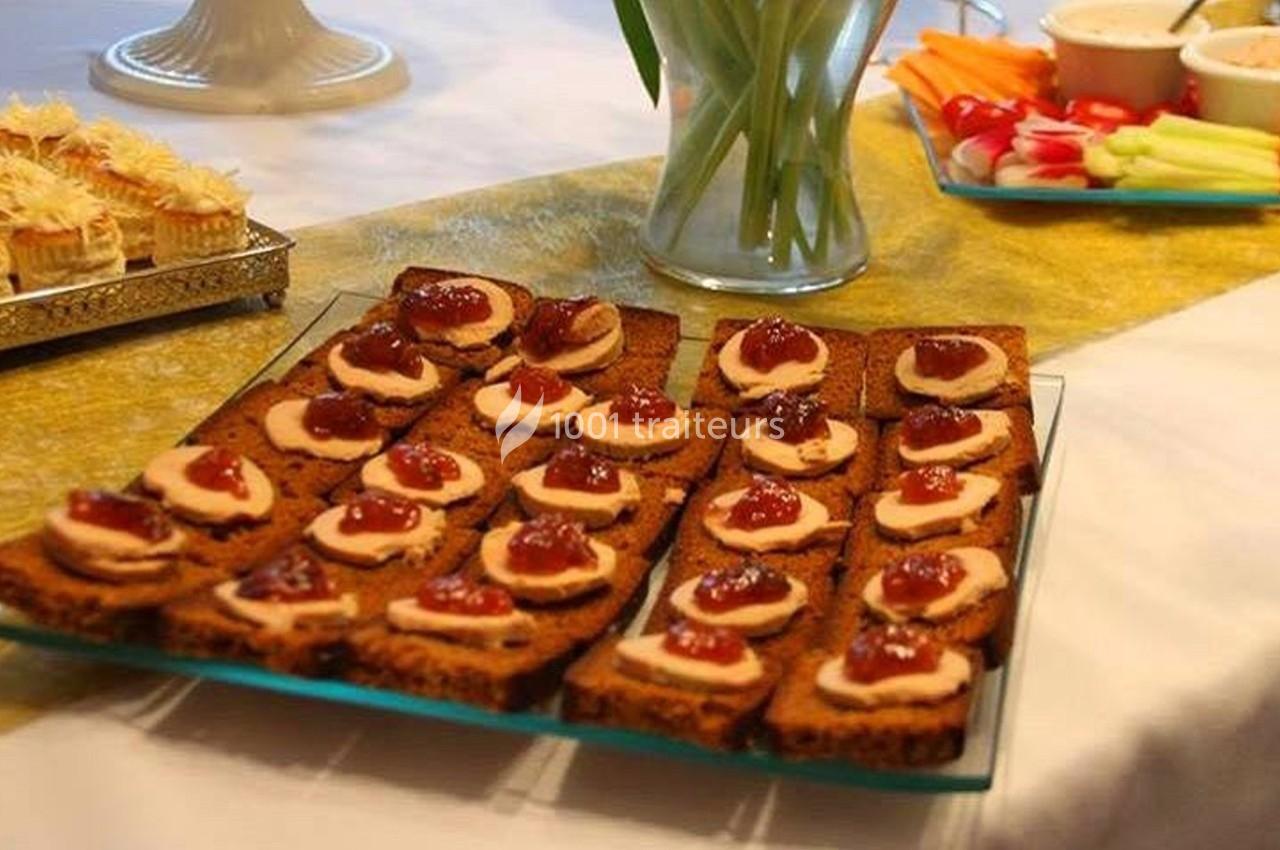 Plateau de toasts garnis de sauce et de condiments, disposé sur une table avec d'autres amuse-bouches et décorations.
