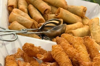 Plateau en métal doré rempli de samoussas dorés et croustillants, posé sur une table blanche.