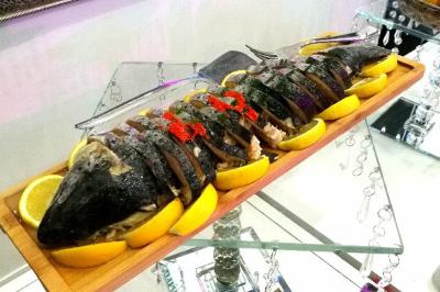 Plateau en métal doré rempli de samoussas dorés et croustillants, posé sur une table blanche.