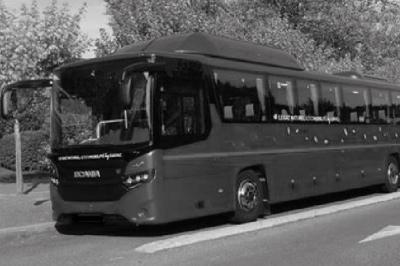 Miniature Regency Limo Coach #5 Alignement de véhicules noirs stationnés devant un bâtiment en pierre avec arcades, sous un ciel dégagé.