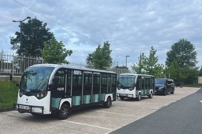 Miniature Regency Limo Coach #17 Alignement de véhicules noirs stationnés devant un bâtiment en pierre avec arcades, sous un ciel dégagé.