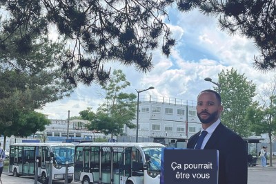Miniature Regency Limo Coach #18 Alignement de véhicules noirs stationnés devant un bâtiment en pierre avec arcades, sous un ciel dégagé.