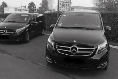 Fourgonnette noire avec portes latérales et arrière ouvertes, montrant un siège accessible et une rampe déployée.