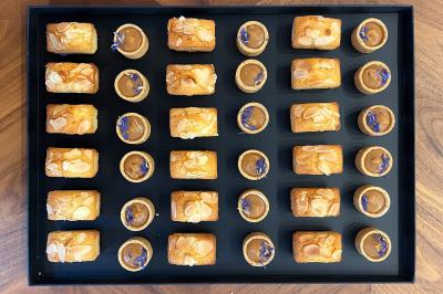 Miniature Traiteur Lyon 2 (Rhône) - Food And Beyond #7 Sandwiches colorés empilés avec des garnitures variées, entourés de roquette et d'olives vertes.