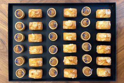 Miniature Traiteur Lyon 2 (Rhône) - Food And Beyond #17 Sandwiches colorés empilés avec des garnitures variées, entourés de roquette et d'olives vertes.