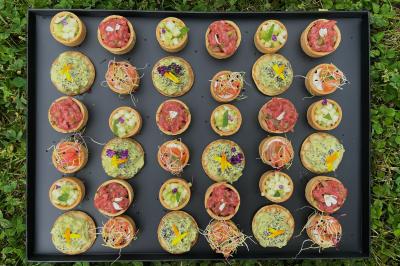 Miniature Traiteur Lyon 2 (Rhône) - Food And Beyond #6 Sandwiches colorés empilés avec des garnitures variées, entourés de roquette et d'olives vertes.