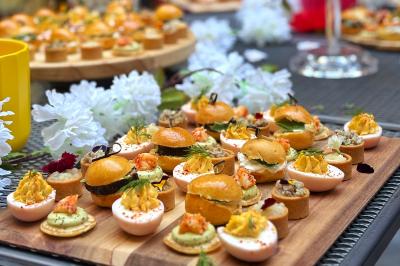 Miniature Traiteur Lyon 2 (Rhône) - Food And Beyond #28 Sandwiches colorés empilés avec des garnitures variées, entourés de roquette et d'olives vertes.